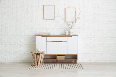 Beyaz tuvaletli, tablolu ve boş çerçeveli odanın içi