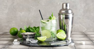Bir bardak taze mojito kokteyli. Limonlu ve sallanan gri fayanslı.