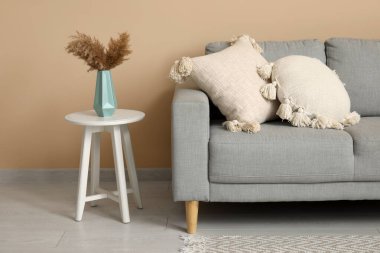 Çimenli kahve masası ve yastıklı kanepe.