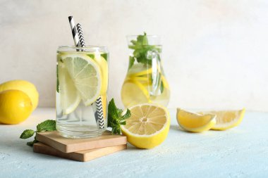 Açık mavi masada naneli bir sürahi taze limonata.