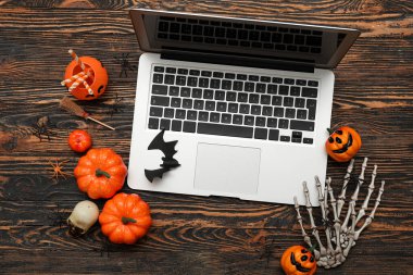 Ahşap arka planda Cadılar Bayramı için modern dizüstü bilgisayar ve dekor kompozisyonu