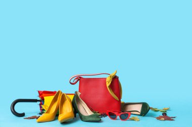 Kırmızı çantalı, güneş gözlüklü, şemsiyeli ve sonbahar yapraklı farklı yüksek topuklu.