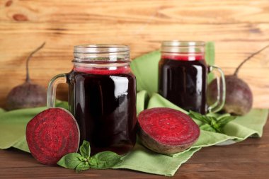 Ahşap arka planda fesleğen ve sebzeli taze pancar suyu.