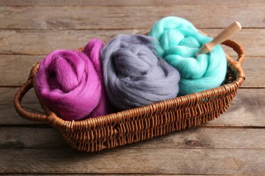 Yünlü sepet ve ahşap arka planda iğne.