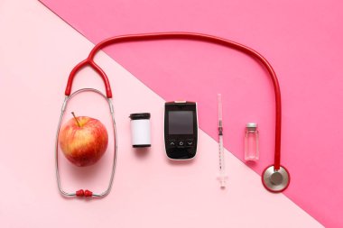 Ensülin ampulü, şırıngası, steteskobu ve arkaplanı elmalı modern glukometre