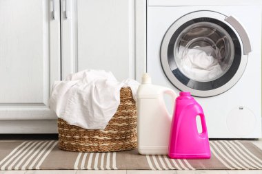 Çamaşır odasında çamaşır makinesinin yanında çamaşır sepeti ve çamaşır sepeti var.