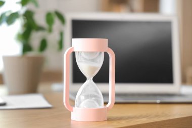 Ofisteki masada pembe kum saati, yakın plan.