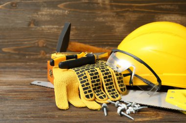 Ahşap arka planda marangoz aletleri ve koruyucu teçhizat