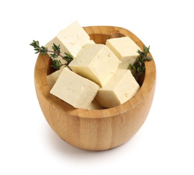 Beyaz arka planda kesilmiş soya peynirli ahşap kase.
