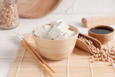 Beyaz arka planda tofu peyniri parçaları olan bir kase