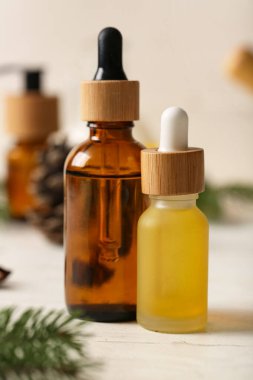 Beyaz ahşap arka planda kozalaklı kozalaklı şişeler.