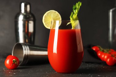 Kereviz, limon dilimi ve siyah grunge arkaplanda domatesli bir bardak Bloody Mary.