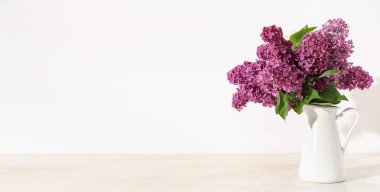 Beyaz arkaplanda bir demet leylak çiçekli vazo ve metin için boşluk