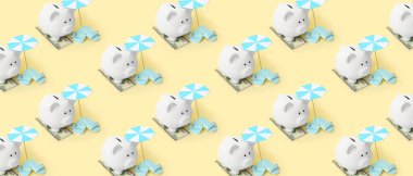 Açık sarı arka planda kumsal aksesuarları ve paralı bir kumbara. Seyahat için tasarruf kavramı