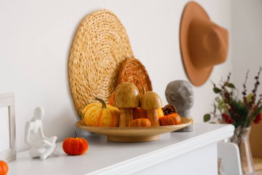 Oturma odasındaki şöminede heykelcik ve balkabağı. Sonbahar konsepti