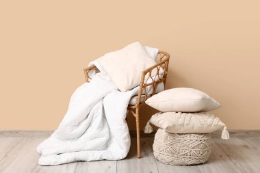 Oda da bej duvarın yanında temiz yatak çarşafları, puf ve yastıklar.