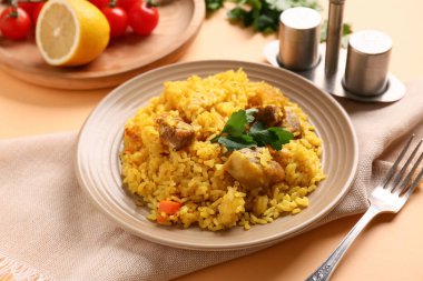 Turuncu arka planda maydanozlu ve limonlu lezzetli pilav tabağı, yakın plan.