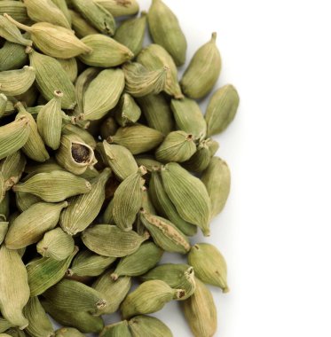 Beyaz arka planda kakule baharatı yığını