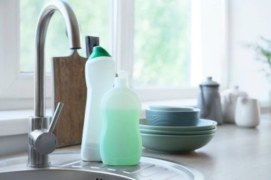 Mutfaktaki lavaboda temiz tabaklar olan deterjanlar, yakın plan.