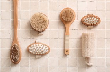 Bej kaplama üzerinde farklı masaj vücut fırçaları olan kompozisyon