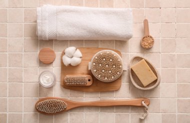 Havlulu kompozisyon, kozmetik ürünler kavanozu, tahta tahta tahta ve bej fayanslı vücut fırçaları.