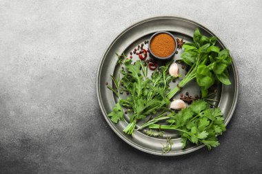 Gri grunge arka planda tepsi, bitki ve baharatlarla kompozisyon