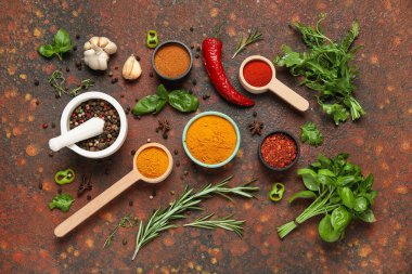 Kahverengi grunge arka planında havan, otlar, kepçeler ve baharatlar içeren kompozisyon, yakın plan