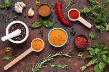 Kahverengi grunge arka planında havan, otlar, kepçeler ve baharatlar içeren kompozisyon, yakın plan