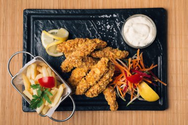 kızarmış tavuk ve patates kızartması karanlık bir tablo, üstten görünüm