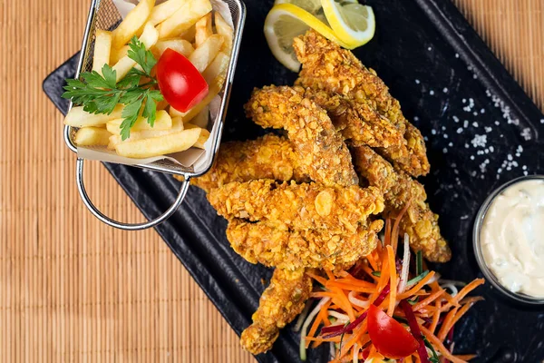 kızarmış tavuk ve patates kızartması karanlık bir tablo, üstten görünüm