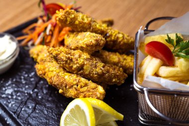 Kızarmış tavuk ve patates kızartması karanlık bir tablo