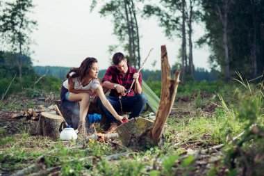 Çay yapmak ve ormanda yiyecek hazırlama mutlu çift