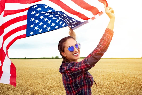 年轻美丽的女人举着美国国旗 — 图库照片