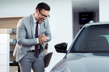 Mutlu işadamı Bayilik showroom, onun yeni otomobil yakınındaki poz