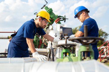 İki mühendis petrol ve doğal gaz rafineri içinde çalışıyor