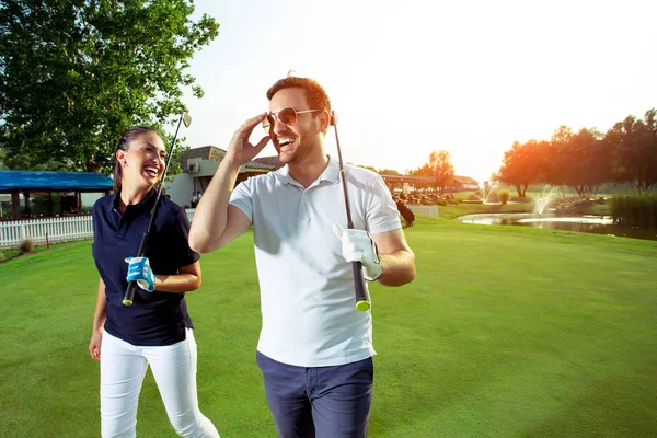 Porträtt Leende Par Anläggning Golfklubbar Stående Fältet — Stockfoto