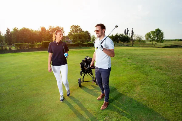 在高尔夫球场打高尔夫的年轻夫妇 — 图库照片
