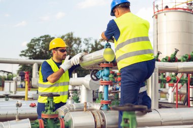 İş kontrol etmek için taşınabilir radyo konuşma ile bir petrol rafinerisi çalışan mühendis