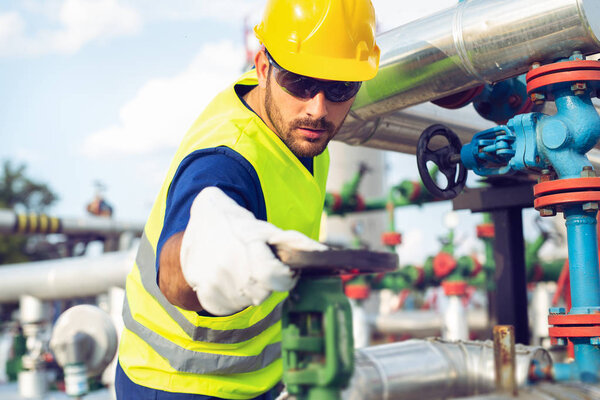 Oil worker turning valve on oil rig