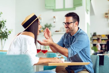 Güzel çift aşık kafede oturuyor. Genç adam kadını besleme ve gülümseyen