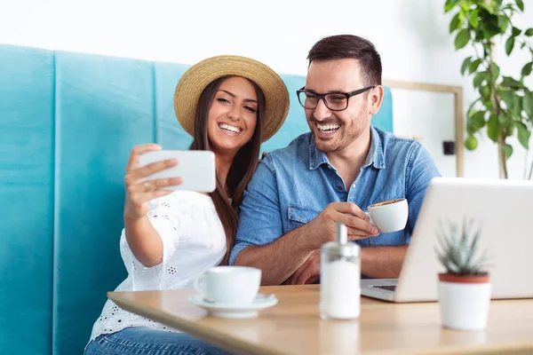 Couple taking selfie by smartphone at restaurant