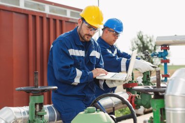İki mühendis petrol ve doğal gaz rafineri içinde çalışıyor