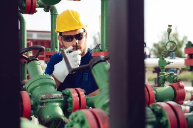 Dizüstü bilgisayar ve bir radyo istasyonunda konuşan petrol pompa üzerinde çalışan bakar
