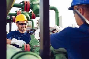İki mühendis petrol ve doğal gaz rafineri içinde çalışıyor
