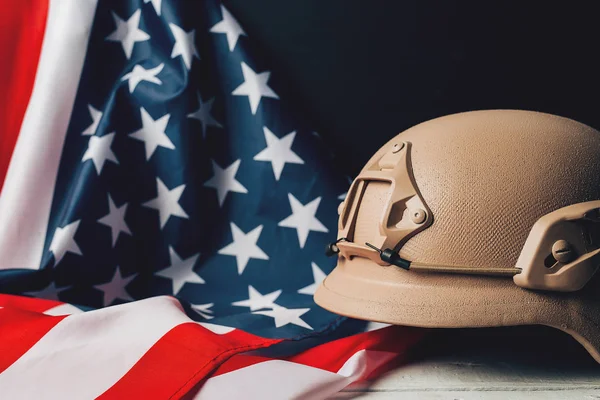 Military helmets and American flag on background
