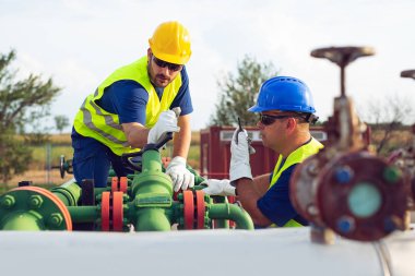 İki mühendis petrol ve doğal gaz rafineri içinde çalışıyor
