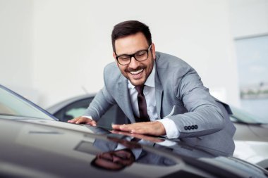 Genç adam yeni bir araç içinde araba Bayilik seçmektir 