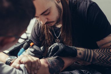 Dövme sanatçısı bir adamın vücudunda bir resim oluşturur