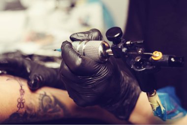     Bir kızın kolunda bir dövme oluşturma dövme sanatçı el yakın çekim 