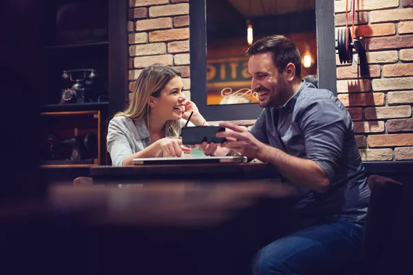 Attractive Male Showing Something His Girlfriend While Having Little Coffee — Stock Photo, Image